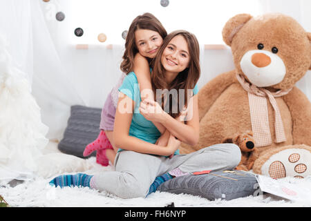 Portrait de deux soeurs de charme agréable assis dans chambre d'enfant à domicile Banque D'Images