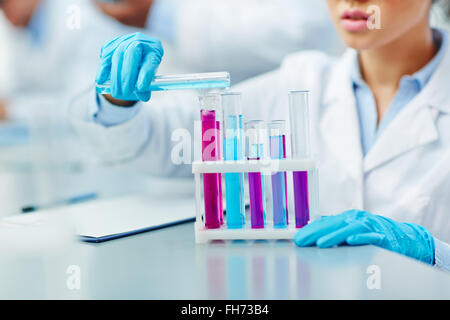 Jeune femme travaillant avec des substances chimiques en laboratoire scientifique Banque D'Images