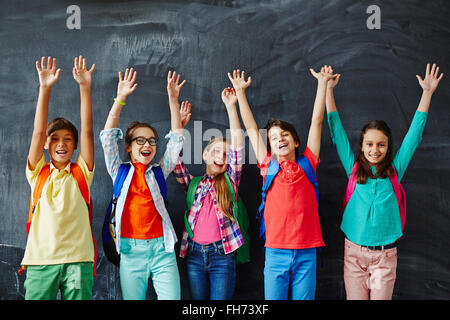 Enfants extatiques mains tandis que l'article par blackboard Banque D'Images