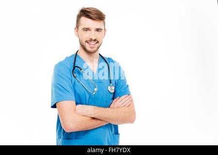 Smiling male doctor standing with arms folded isolé sur fond blanc Banque D'Images