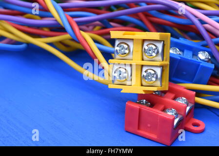 Câbles électriques couleur avec blocs de jonction sur fond de bois bleu Banque D'Images