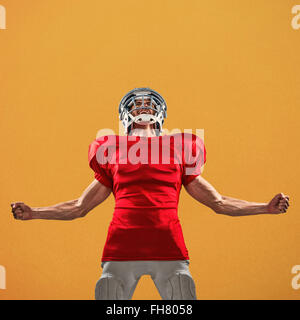 Image composite de joueur de football américain agressif en maillot rouge hurlant Banque D'Images