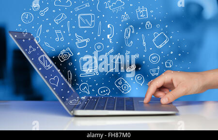 Ordinateur portable avec icônes et symboles dessinés à la main, Banque D'Images