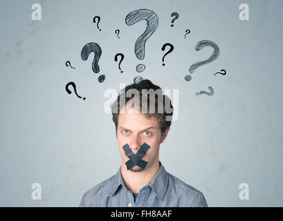 Jeune homme avec la bouche collée et symboles d'interrogation Banque D'Images
