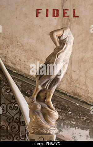 Ornate statue sur l'escalier de marbre avec Fidel écrit mural au-dessus dans un immeuble à La Havane, Cuba, Antilles, Caraïbes, Amérique Centrale Banque D'Images