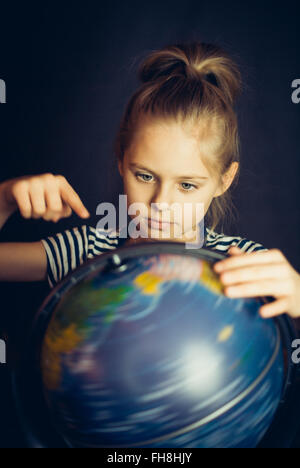 Belle petite fille tournoie globe Banque D'Images