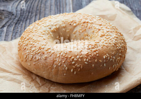 Bagel sésame en sac de papier sur la table en bois Banque D'Images