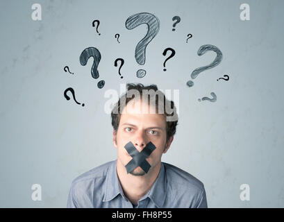 Jeune homme avec la bouche collée et symboles d'interrogation Banque D'Images