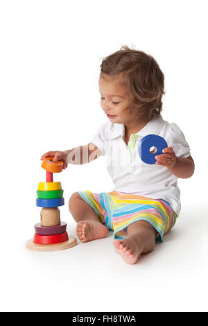 Bébé fille jouant avec des briques de couleur sur fond blanc Banque D'Images