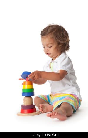 Bébé fille jouant avec des briques de couleur sur fond blanc Banque D'Images