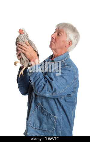 Fier senior man holding Wyandotte poulet sur fond blanc Banque D'Images