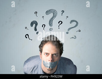 Jeune homme avec la bouche collée et symboles d'interrogation Banque D'Images