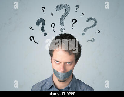 Jeune homme avec la bouche collée et symboles d'interrogation Banque D'Images