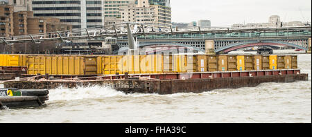 Remorqueur tirant deux barges conteneurs jaune contenant sur Tamise Banque D'Images