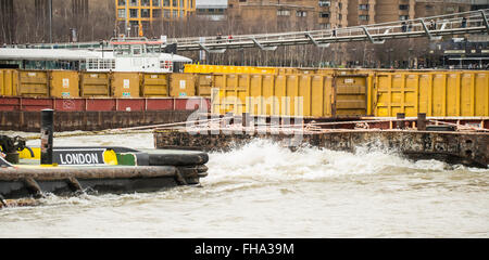 Remorqueur tirant deux barges conteneurs jaune contenant sur Tamise Banque D'Images