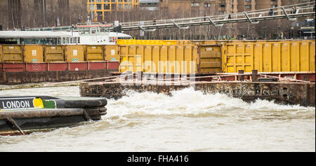 Remorqueur tirant deux barges conteneurs jaune contenant sur Tamise Banque D'Images