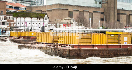 Remorqueur tirant deux barges conteneurs jaune contenant sur Tamise Banque D'Images