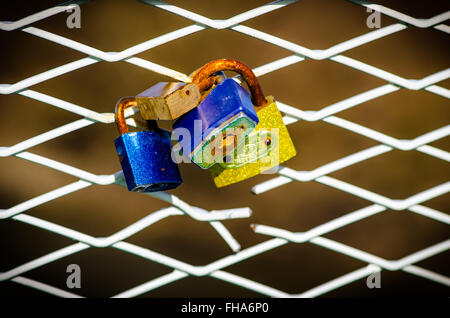 Cadenas colorés sur la balustrade blanche Banque D'Images