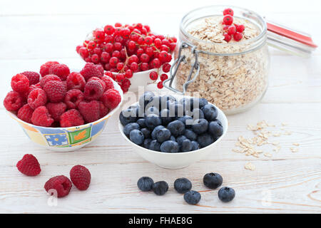 Petit-déjeuner - baies, de fruits et de muesli sur bois blanc Banque D'Images