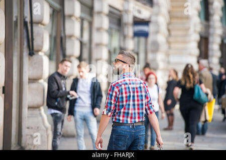 Hipster man shopping dans les rues de Londres, vue de dos Banque D'Images