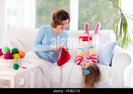 Mère et fille écharpe de laine à tricoter. L'enseignement de mère enfant à tricoter. Artisanat et passe-temps pour les parents et les enfants. Banque D'Images