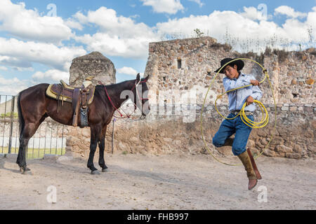 Un Mexicain charro ou pratiques cowboy roping compétences avec son cheval à une hacienda ranch dans Alcocer, au Mexique. La Charreada est une forme traditionnelle mexicaine de rodeo et teste les compétences de l'équitation à cowboy au lasso, et le contrôle du bétail. Banque D'Images