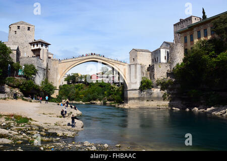 Les gens se rassemblent pour regarder les plongeurs locaux et touristes aventureux sauter du 16ème siècle reconstruite pont ottoman Stari Most ou vieux pont de Mostar. Banque D'Images