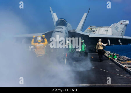 Les marins de la Marine américaine d'ordonner un F/A-18E Super Hornet dans le poste de pilotage à bord de la classe Nimitz supercarrier à propulsion nucléaire USS John C. Stennis, 23 février 2016 dans la mer des Philippines. Banque D'Images