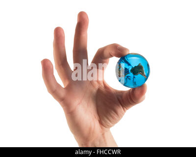 Photographie d'une part, faire un signe "OK" tout en maintenant un globe de verre de la terre. Banque D'Images