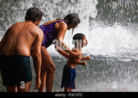Une famille joue dans la cascade de CHAMPEE situé sur le PLATEAU DES BOLAVENS près de Pakse, LAOS DU SUD - MR Banque D'Images