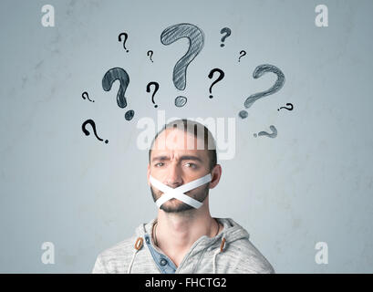 Jeune homme avec la bouche collée et symboles d'interrogation Banque D'Images