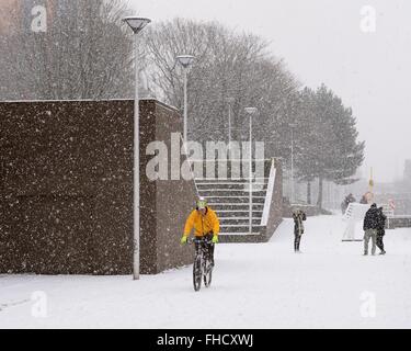 Un cycliste bravant la neige sur Custom House Quay passerelle, Clyde Street, Glasgow, Scotland, UK Banque D'Images