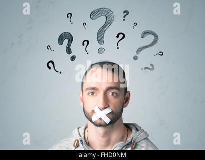 Jeune homme avec la bouche collée et symboles d'interrogation Banque D'Images