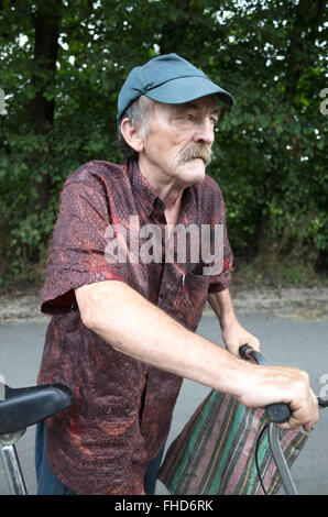 L'âge de 70 ans gentleman polonais transportant un sac de voyage de shopping local utilise location pour le transport. La Pologne centrale Rzeczyca Banque D'Images