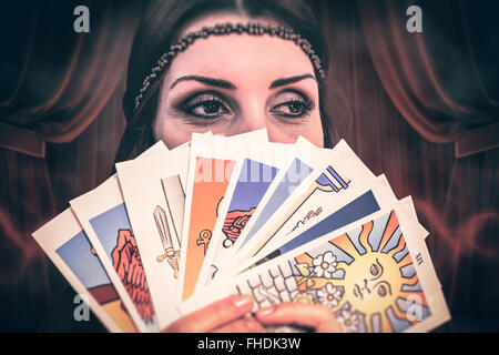 Image composite de fortune teller holding Tarots cartes tout en regardant ailleurs Banque D'Images