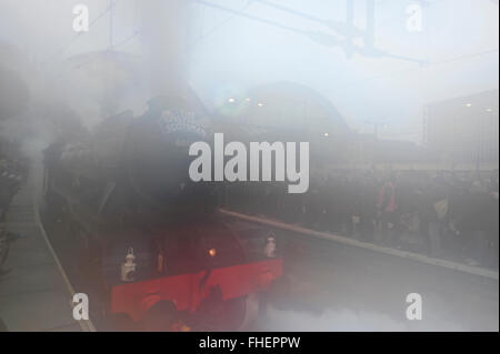 La gare de Kings Cross, London, UK. 25 Février, 2016. Le conducteur souffle la vapeur comme le Flying Scotsman quitte Kings Cross - qui se condense sur les verres de toutes les photographes de presse. Locomotive à vapeur emblématique Flying Scotsman quitte la station Kings Cross plate-forme 1 à 07.40h à un voyage inaugural de célébration courir le long de la ligne principale de la côte Est après une longue décennie 4.2Million livre restauration. Ce parcours historique, entre Londres et New York, est la première occasion pour le public de voir le bien-aimé en vert et du moteur portant sa plaque signalétique iconique. Credit : Malcolm Park editorial/Alamy Liv Banque D'Images