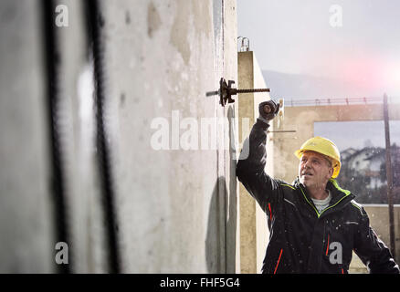 Travailleur de la construction au chantier de construction, l'enlèvement des coffrages, Innsbruck Land, Tyrol, Autriche Banque D'Images