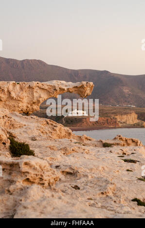 Formations de roche volcanique de Playa del Arco beach, Los Escullos avec villa espagnole et les montagnes en arrière-plan, Cabo de Gata Banque D'Images