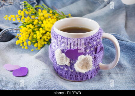 Tasse de thé d'hiver et mimosa fleurs sur fond bleu denim Banque D'Images