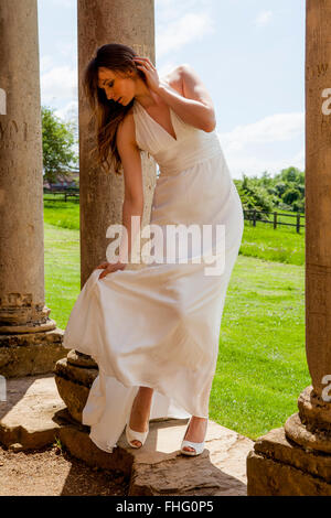 Dame en blanc ballgown sur portique de bâtiment en ruine Banque D'Images