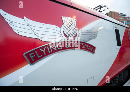 La gare de Kings Cross, London, UK. 25 Février, 2016. Virgin Trains de jour moderne Flying Scotsman liveried Class 91 train quitte la gare de Kings Cross Platform 0 à 08h00 pour Edimbourg via la côte est (ligne principale), environ 50 minutes après le départ de l'emblématique locomotive à vapeur. Credit : Malcolm Park editorial/Alamy Live News Banque D'Images
