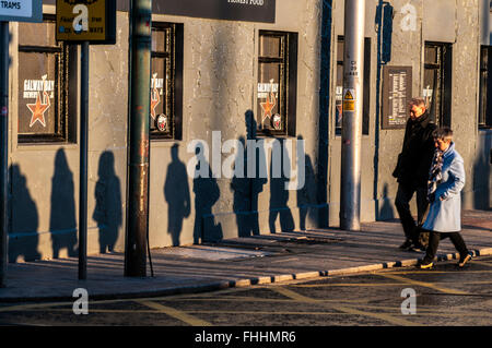 Les ombres des gens au travail à pied, à Dublin, en Irlande, au début de l'hiver matin Banque D'Images