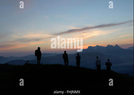 Les randonneurs regardant le lever du soleil depuis le sommet de la Kitzbüheler Horn. Le Tyrol, Autriche. Banque D'Images