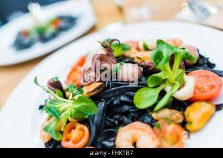 Les pâtes de fruits de mer Spaghetti noir avec des calmars et d'autres fruits de la mer. Spaghettis Ai Frutti di Mare. Des spécialités italiennes. Banque D'Images