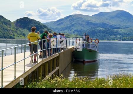 Parc National de Lake District. Les touristes à bord d'un lancer à partir d'une jetée sur le lac Ullswater. Banque D'Images