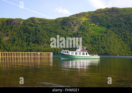 Parc National de Lake District. Les touristes sur une jetée à l'approche d'un lancement sur le lac Ullswater. Banque D'Images