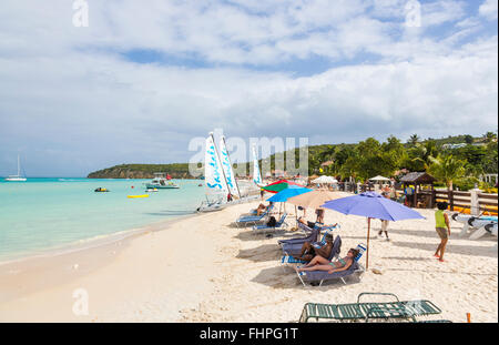 Vue panoramique de Dickenson Bay, au nord d'Antigua, de parasols, de chaises longues et de sandales bateaux à voile sur la plage Banque D'Images