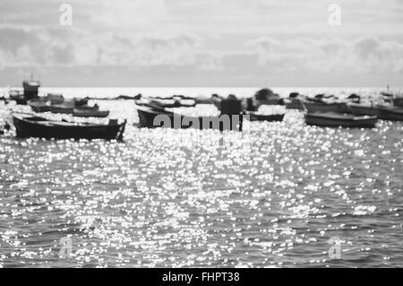 Arrière-plan flou de bateaux contre la lumière du soleil et brille sur la surface de l'eau, image en noir et blanc Banque D'Images