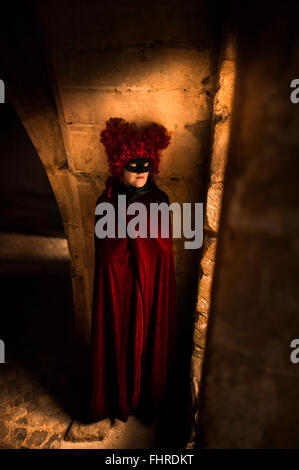 Figure féminine portant perruque rouge debout dans château par la fenêtre Banque D'Images