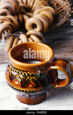 Des Bagels et verre de lait sur fond parsemé de farine dans le style slave Banque D'Images